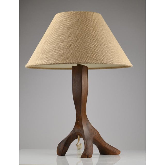 Striking French table lamp from the 1950s, crafted in solid olive wood and embodying a sculptural Brutalist aesthetic. The...