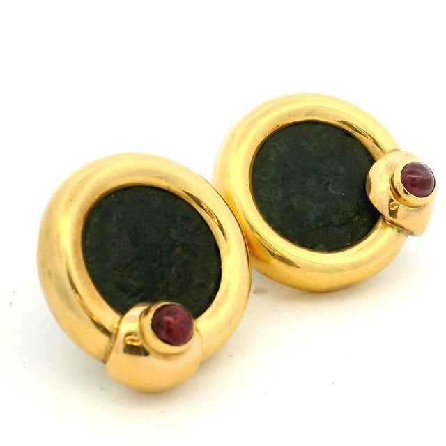 A striking pair of vintage earrings crafted in 18 karat yellow gold, each centered with a bronze coin set within a...