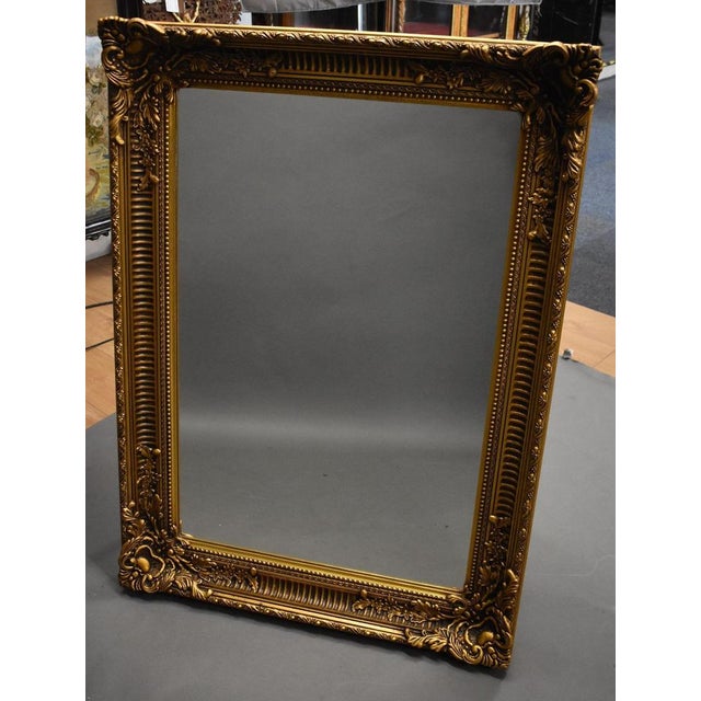 Mid-20th Century Ornate Gilt Mirror This striking mid-20th century mirror features an exquisitely detailed gilt frame with...