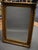 Mid-20th Century Ornate Gilt Mirror This striking mid-20th century mirror features an exquisitely detailed gilt frame with...