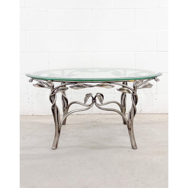 Robb & Stucky sculptural coffee table is crafted in hand-forged wrought-iron, adorned with artfully intertwined vines and...