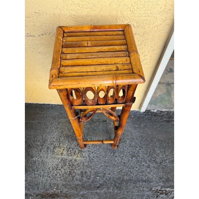This vintage burnt tortoise bamboo Side table. This versatile furniture piece is suitable for showcasing plants or acting...