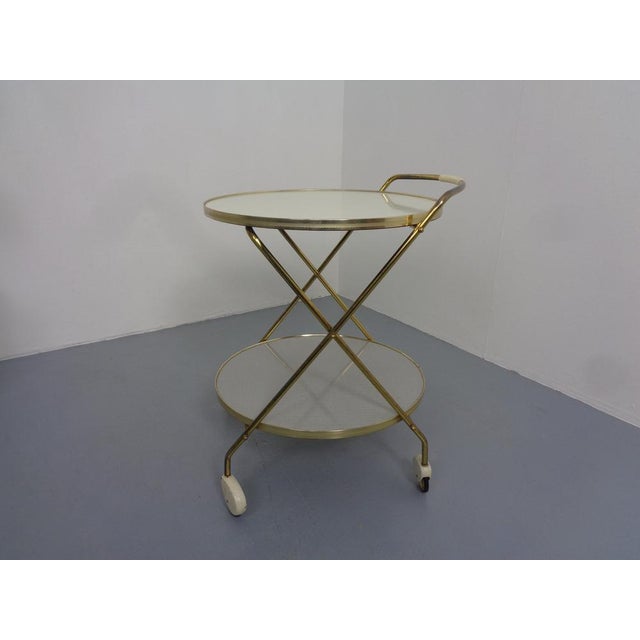 Rollable bar wagon with brass -colored metal frame.