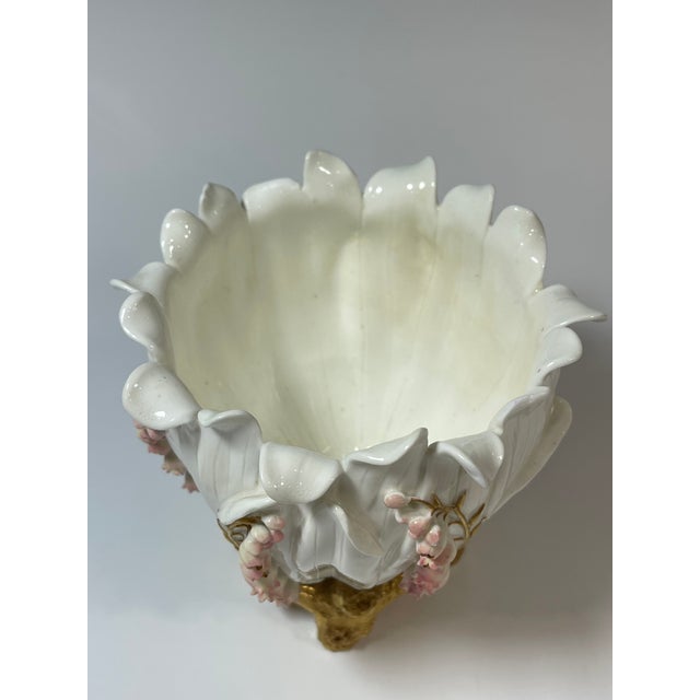 It is decorated with hand-painted, raised details of lily of the valley flowers in white and pink, with gold stems and...