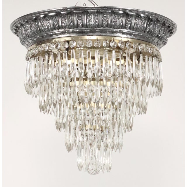 Neoclassical style flush mount chandelier with five tiers of crystals known as "wedding cake" style. It features clear...