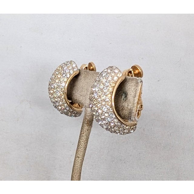 1960s goldtone pavé round clear rhinestones half hoop clip and adjustable screw back earrings. Marked "©Vendome" on the...