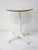 A simple and elegant white pedestal side table with metal star base and round top in white Laminate . The tops edge has a...