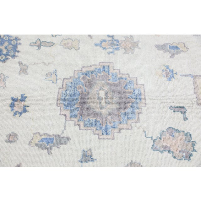 This modern Turkish Oushak rug is a stunning piece of art that has been handwoven using traditional techniques by skilled...