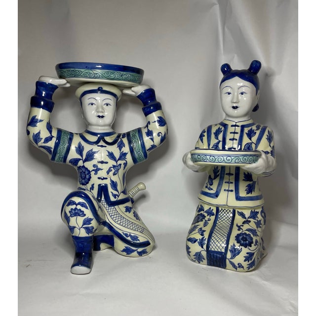 A striking complementary pair of mid-20th-century Chinese hand-painted porcelain court figures, each modeled standing and...