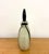 A vintage hand-blown art glass decanter featuring a rounded ivory body accented by deep black vertical bands and applied...