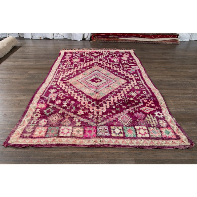 Beautiful hand-knotted vintage tribal wool rug with a purple field, accented with various shades of pink and green, circa...