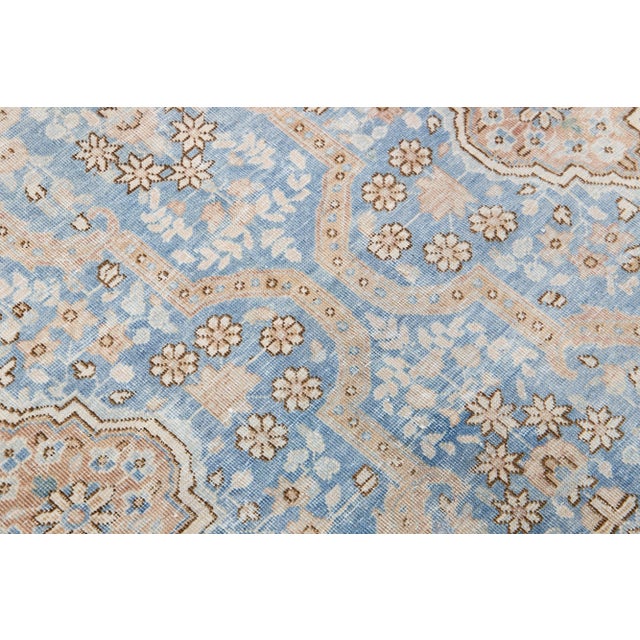 Beautiful antique Tabriz hand-knotted wool rug with a blue color field. This Persian rug has a designed frame with brown...
