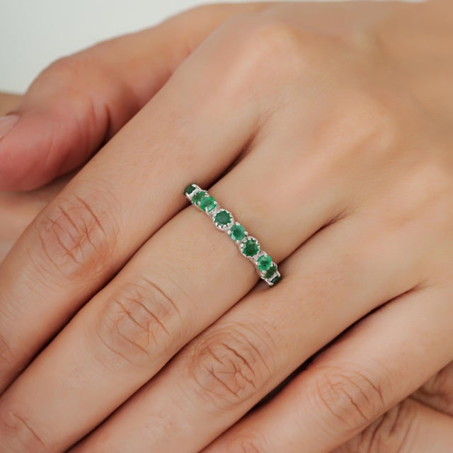 The Modern Belle 0.97 Ct Natural Emerald Half Eternity Band Ring is a graceful expression of timeless elegance, crafted in...