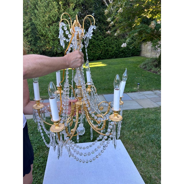Pair of 6 light French style brass and crystal chandeliers, with crystal swags and drops and center hanging crystal ball....
