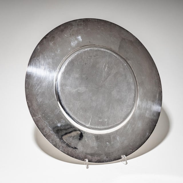 Pair of minimalist silver charger plates featuring a smooth well and plain rim. The subtly profiled edge adds a touch of...