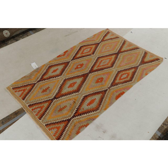 Originating from Turkey circa 1950-1960, a 5x7 vintage Turkish kilim rug exemplifying mid-century tribal sensibilities....