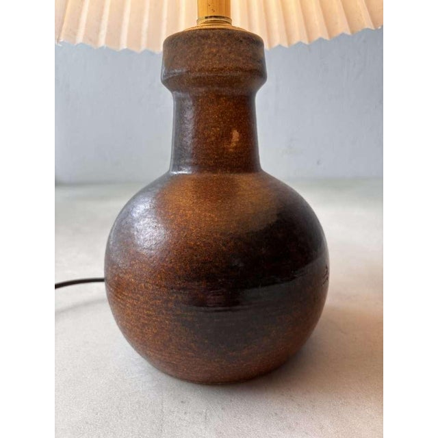 A unique ceramic table lamp from Denmark, handmade in the 1960s. Its minimalist shape and warm earth tones make this lamp...