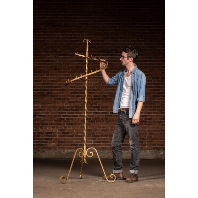 Freestanding Hollywood Regency display stand crafted of painted wrought iron with an elegant gilt finish. The design...