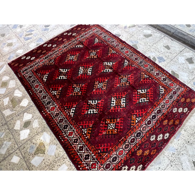 This exquisite high-quality hand-knotted wool area rug showcases a traditional Turkmen Yomut tribal design. The striking...