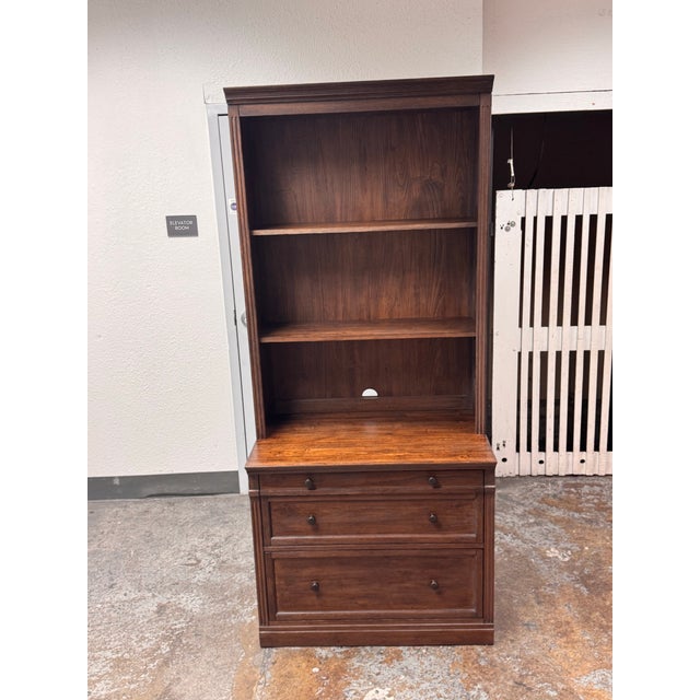 Design Plus Gallery presents the Livingston Bookcase from Pottery Barn. This two-piece wooden unit showcases a traditional...