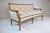 A unique French Louis XVI style small scale sofa, beautifully balanced with subtle crescent curved frame and ornate hand...