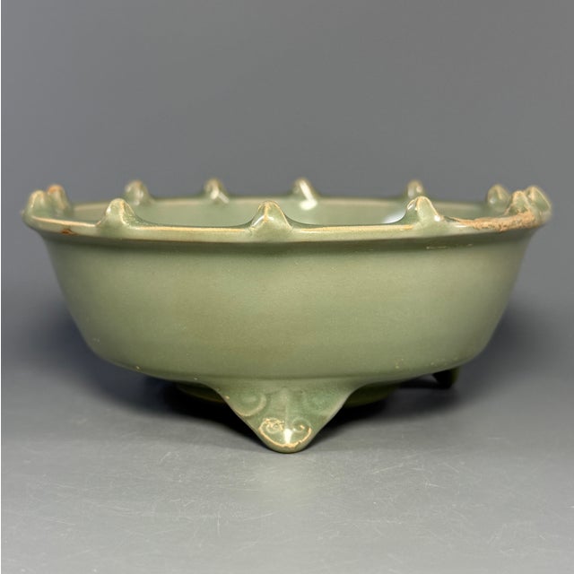 Fine antique Chinese celadon tripod bowl. Three short supporting feet, foliate rim with raised studs, relief motif inside...
