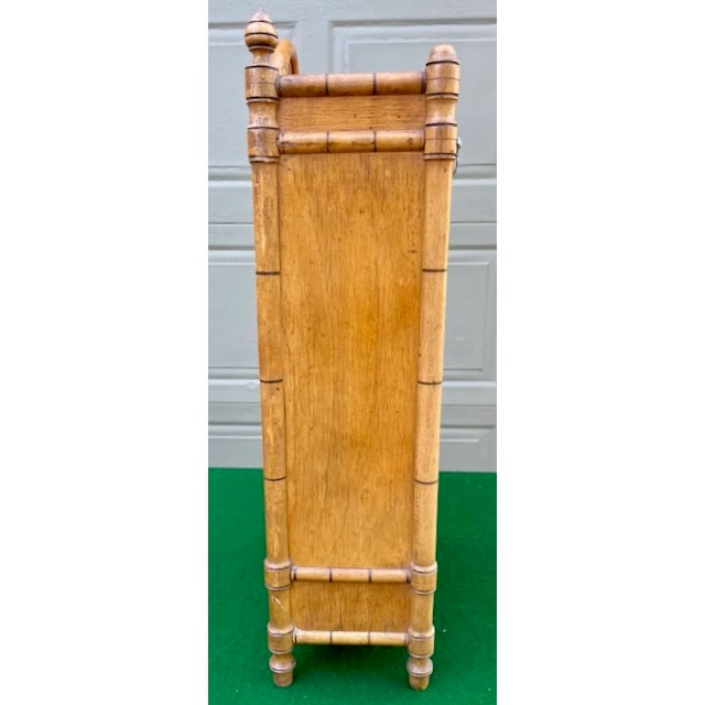 This diminutive French faux bamboo spice cabinet has a serpentine pediment above the vertical rectangular case, with...