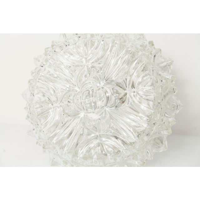 Round, clear ceiling light with a rose-like floral design on top, dating from the 1960s. It is in excellent condition, and...