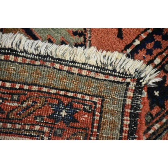 Vintage hand-knotted tribal area rug featuring a richly patterned salmon field with deep indigo medallions and intricate...