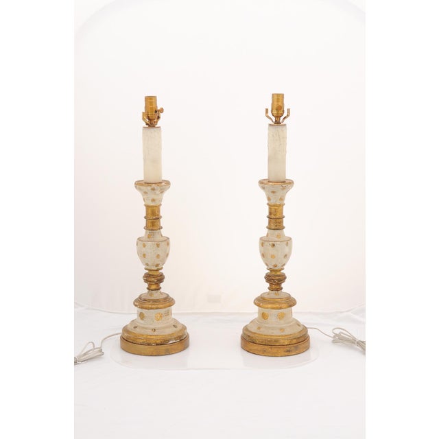 These striking lamps feature hand-carved wooden bodies and are are finished with a heavily distressed, creamy off-white...