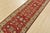 A traditional Kazak runner hand-knotted with fine wool on a cotton foundation. This oriental rug features a botanical...