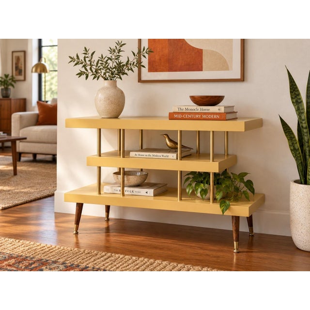 A distinctive vintage mid-century modern three-tier console table featuring a sculptural staggered design, open shelving,...