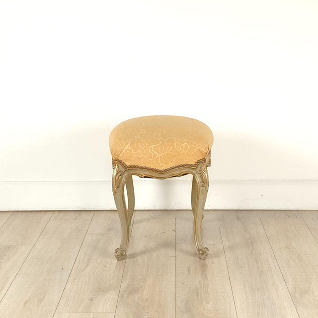 A French painted and gilt upholstered stool, 19th century.