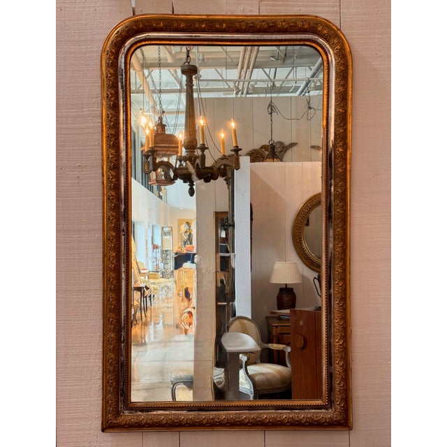19th century French Louis Philippe mirror, the tall frame with rounded top corners. Its wide gilt border carries a running...