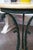 This is an attractive French green-painted and parcel gilt circular iron table. The Faux Travertine top is supported by...