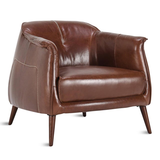 Modern gumdrop shape chestnut brown leather chair with baseball stitch and round solid oak wood legs. Each may have...