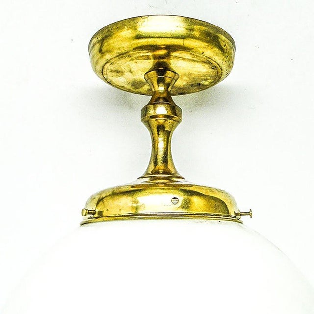 The pendant lamp was produced in the 50s. It is made in the art deco style. The construction is brass, glass shades. It is...
