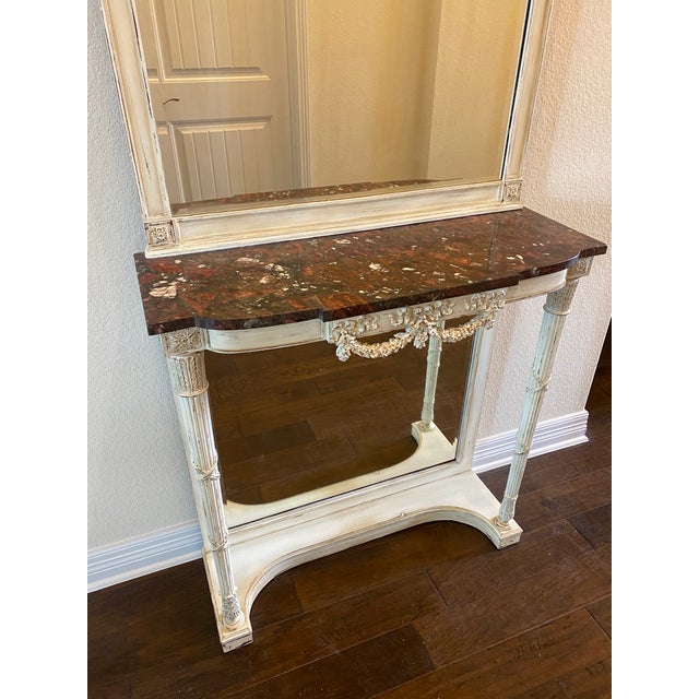 Elegant French antique marble top console table with removable mirror. This piece features carved columns, beveled...