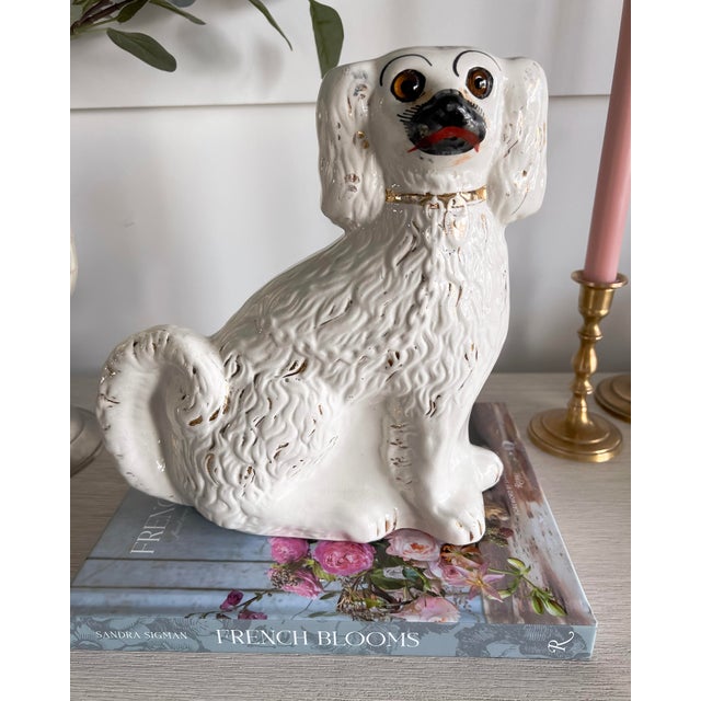 A delightfully expressive Staffordshire-style spaniel that captures the warmth and whimsy of traditional English cottage...