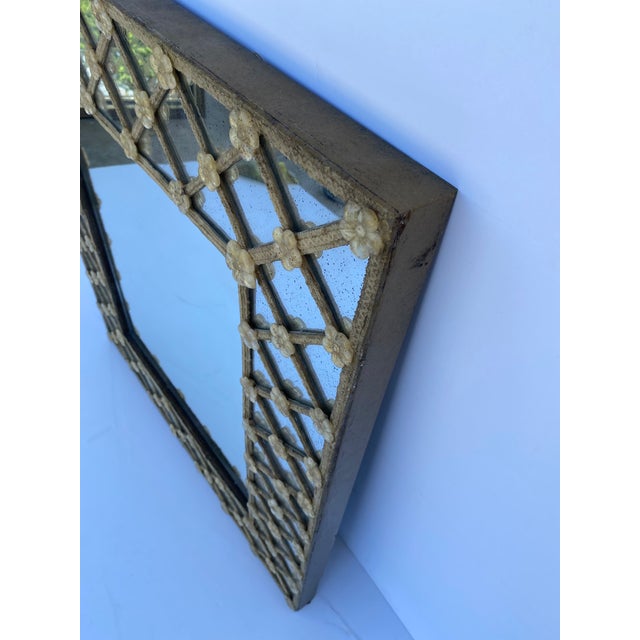 Modern Venetian-style wall mirror. The mirror is decorated with faux-glass flowers.