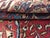 Vintage handwoven sarouk rug featuring an ornate design on a soft red field with light blue corner spandrels. Colors:...