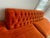 Large armless sofa with tufted back and original orange textured velour. Very good+ original condition,small, 2" tear...