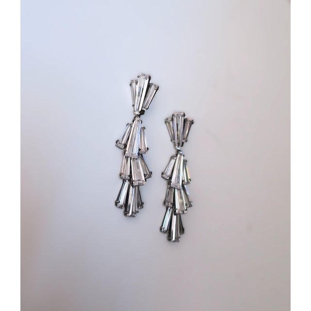 A gorgeous pair of diamond-like crystal dangle earrings by Jarin. Beautiful baguette cut crystals set in rhodium plate...