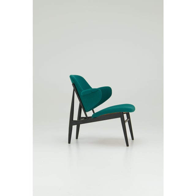 This lounge chair was designed by Danish architect Ib Kofod-Larsen in 1953. The design features a curved plywood shell...