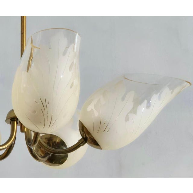 A beautiful brass chandelier with glass shades, decor with leaves. Made by carl erik bodén for glössner, sweden 1940/50s....