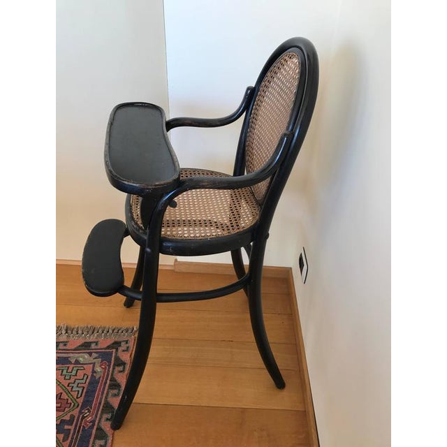 Thonet children's chair Complete with eating tablet and foot suppor.t Blackened beech. All original parts. This piece is...