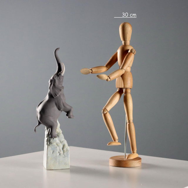 Polychrome biscuit porcelain sculpture depicting an elephant balancing on a rock. Balance Elephant series, number 8200....