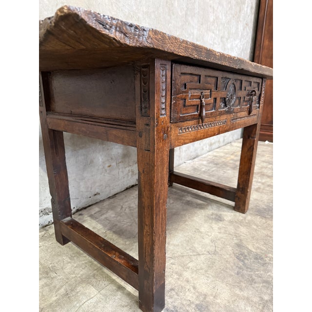 18th century Spanish trestle-leg table featuring a beautifully timeworn plank top and richly carved apron with original...