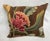 An exquisite antique-style pillow upholstered in richly woven 19th-century tapestry, set against a deep warm brown ground...