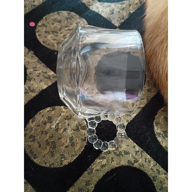 Five-piece vintage clear pressed glass decorative set featuring a matching hobnail-style toothpick holder, two petite bud...